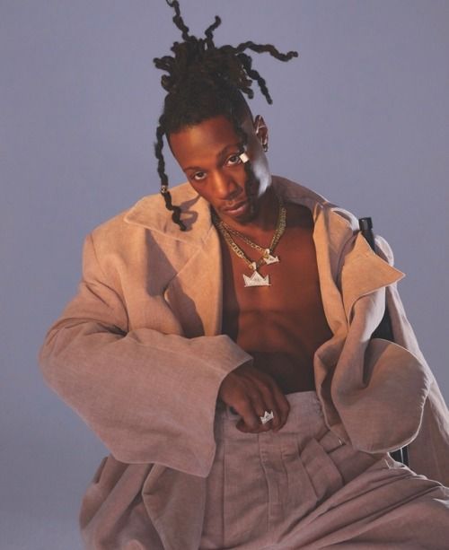 a man with dreadlocks sitting on the ground