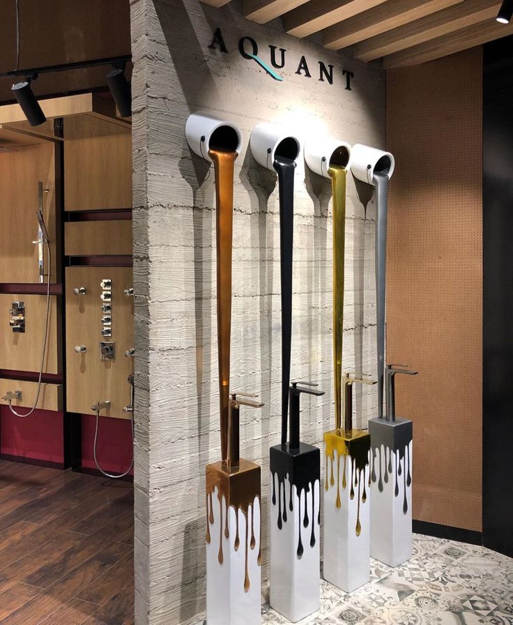 four different types of modern bathroom fixtures on display in an office building with wood flooring