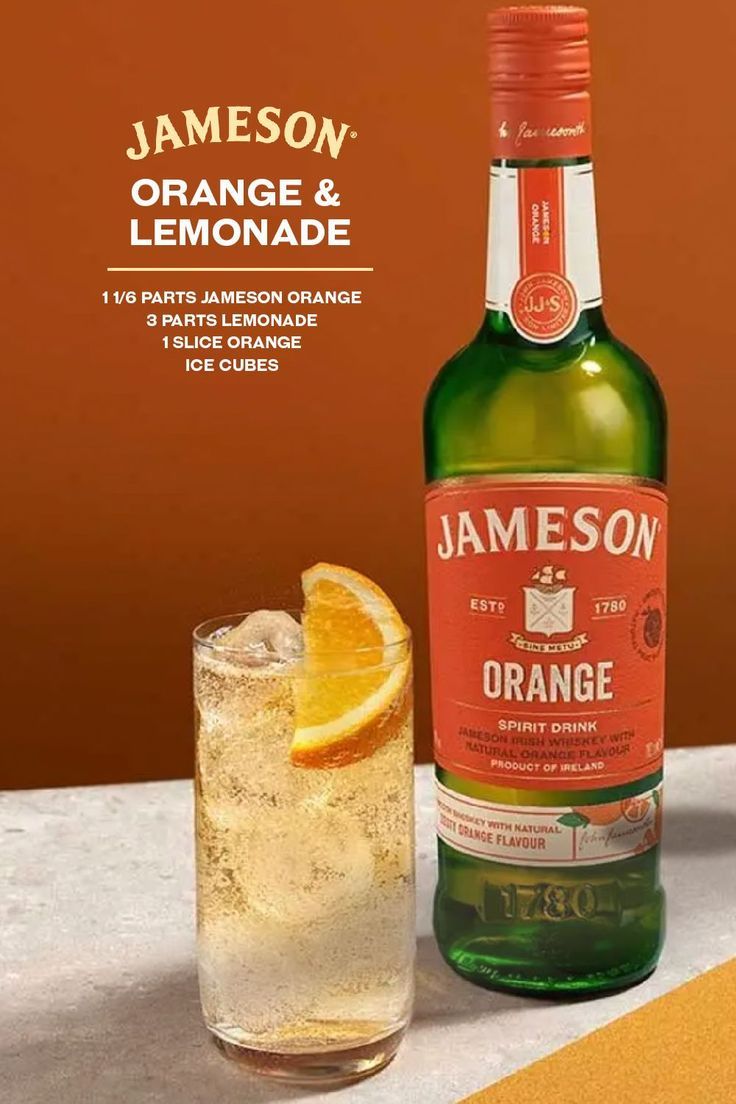 an orange and lemon drink next to a glass on a table with the label jameson & lemonade