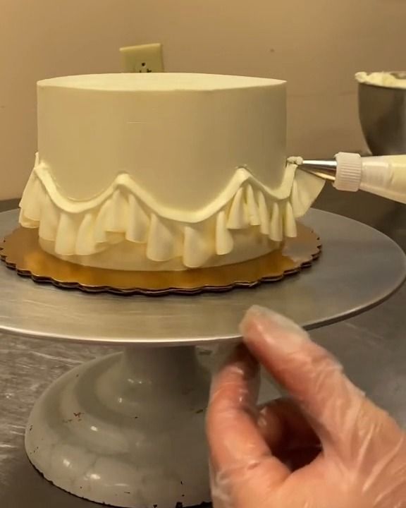 a person is decorating a cake with icing