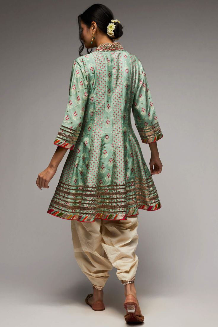 Editor's Note Indulge in the elegance of the tilla kurta and dhoti set, intricately embroidered with zardosi work and adorned with a strong floral butta and geometric jaal. Delicately enhanced with tiny motifs in silver foil, the ensemble exudes a subtle shimmer and richness. Gota motifs scattered all over accentuate the neckline, adding to its charm. Fabric: Kurta: tussar silk, dhoti: cotton Color: Green Component: Kurta and dhoti Occasion: Festive Note: Product colour may slightly vary due to Zardosi Work, Silver Foil, Mint Green, Foil, Mint, Festival, Silk, Floral, Green