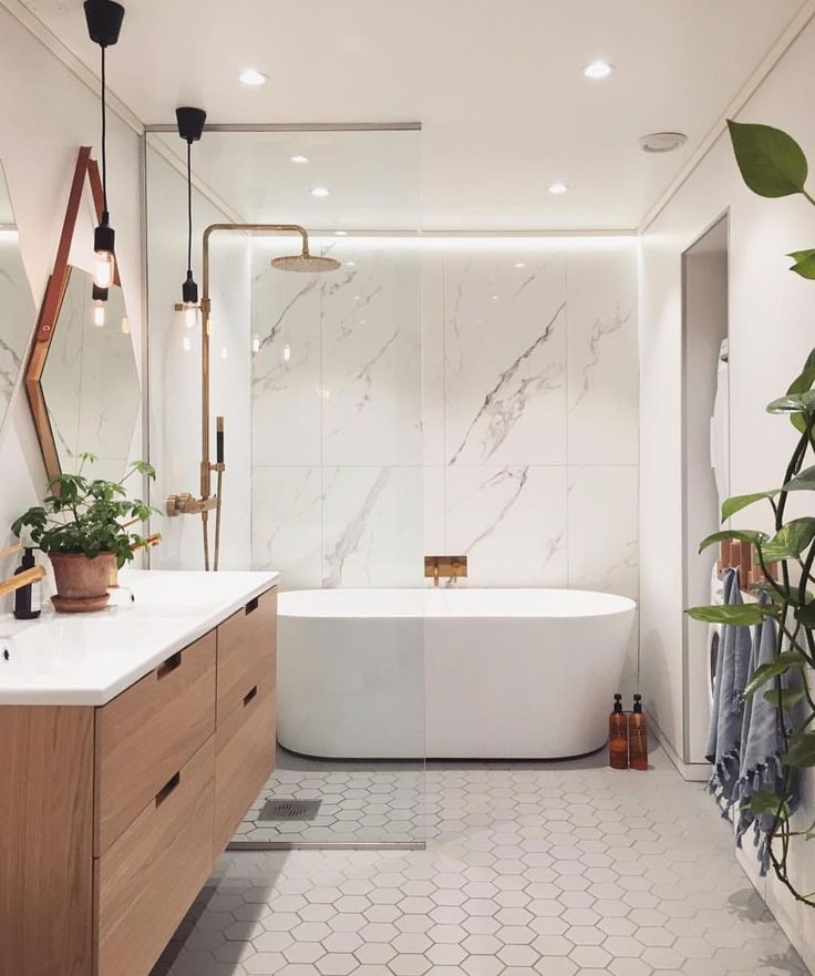 a bathroom with a bathtub, sink and mirror in it's center area