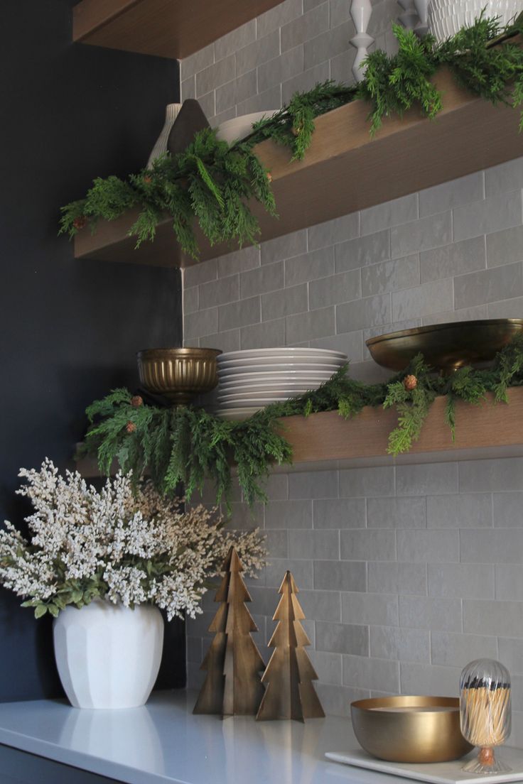 christmas decorations are displayed on the shelf in front of a brick wall and gold dishes