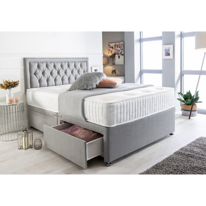 a bed with two drawers underneath it in a room