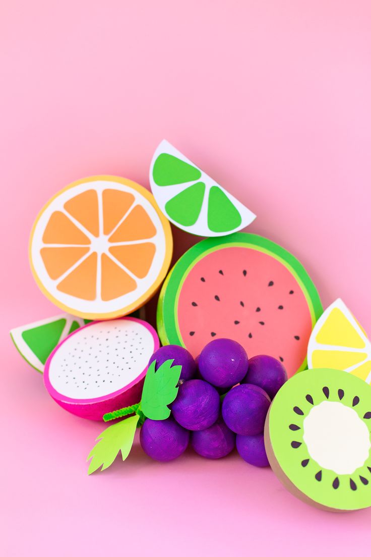 various fruits are arranged on a pink surface