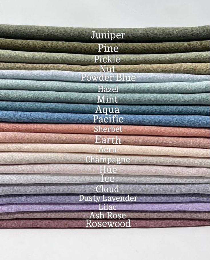 a stack of different colored shirts with names on them