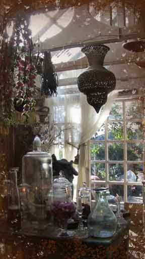 a table with vases and other items on it in front of a large window