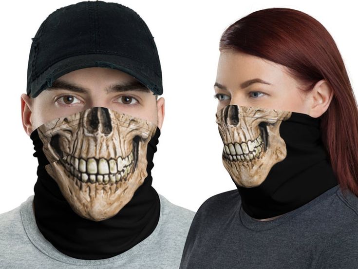 two people with their faces painted to look like skeletons, one is wearing a black hat and the other has red hair