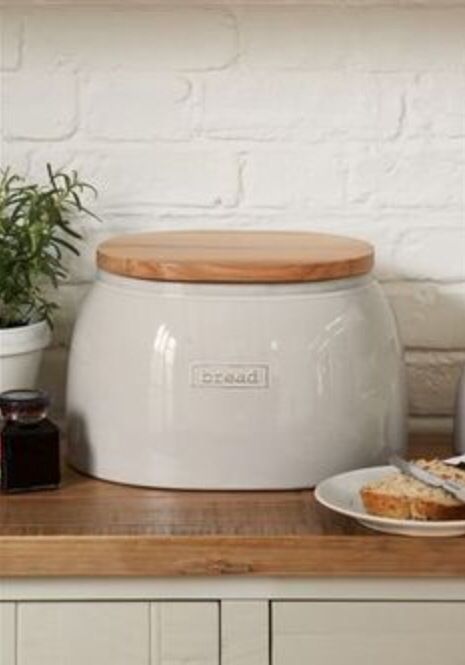 a large white pot sitting on top of a counter next to a plate with food