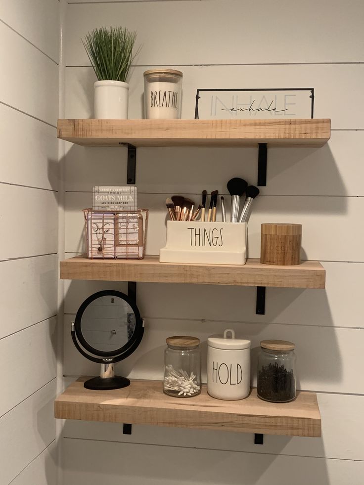 the shelves in the bathroom are organized with items such as candles, jars and other things