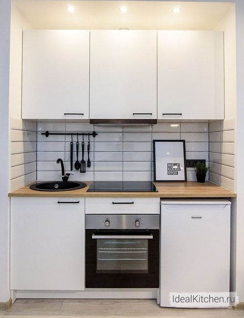 a kitchen with white cabinets and black appliances