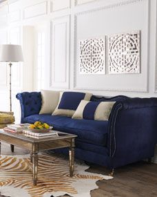 a living room with white walls and blue couches in the center, zebra rug on the floor