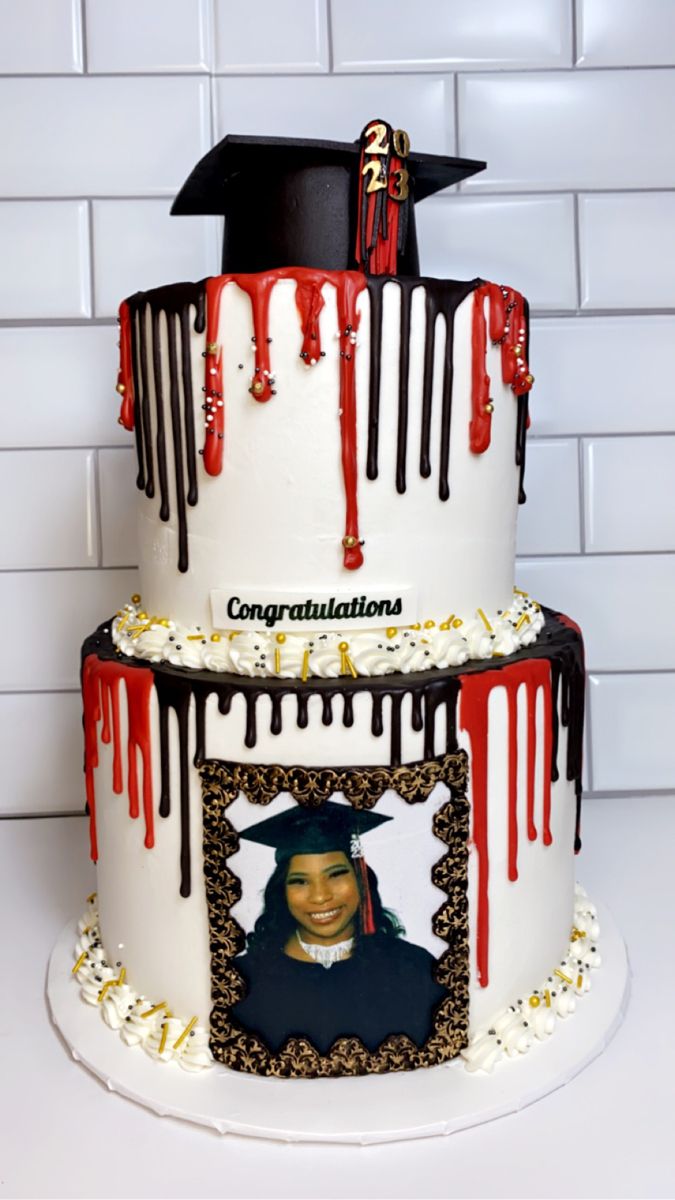 a three tiered cake decorated with an image of a graduate and dripping red icing