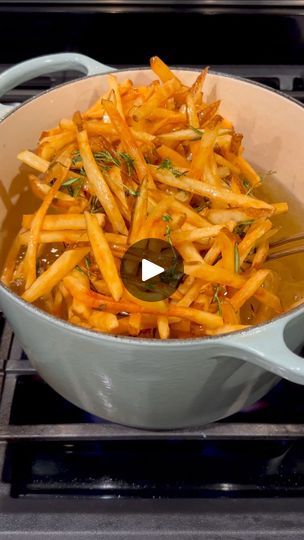 french fries being cooked in a pot on the stove