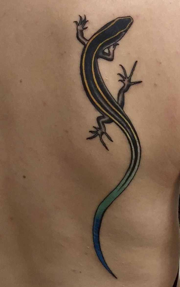 a lizard tattoo on the back of a woman