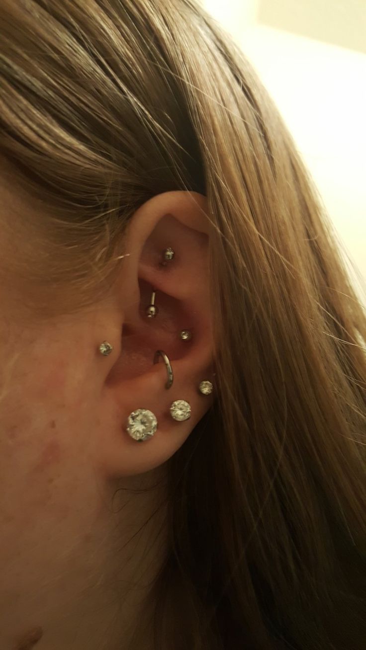 a close up of a person's ear with three different piercings on it