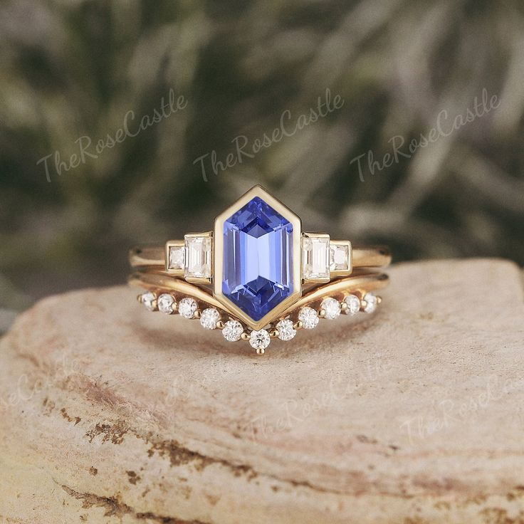 a blue and white diamond ring sitting on top of a wooden block with diamonds around it