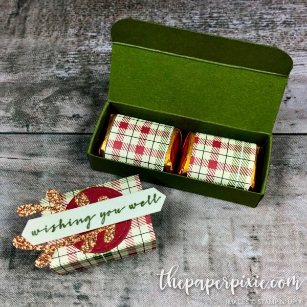 two wrapped gift boxes sitting on top of a wooden table next to an empty tag