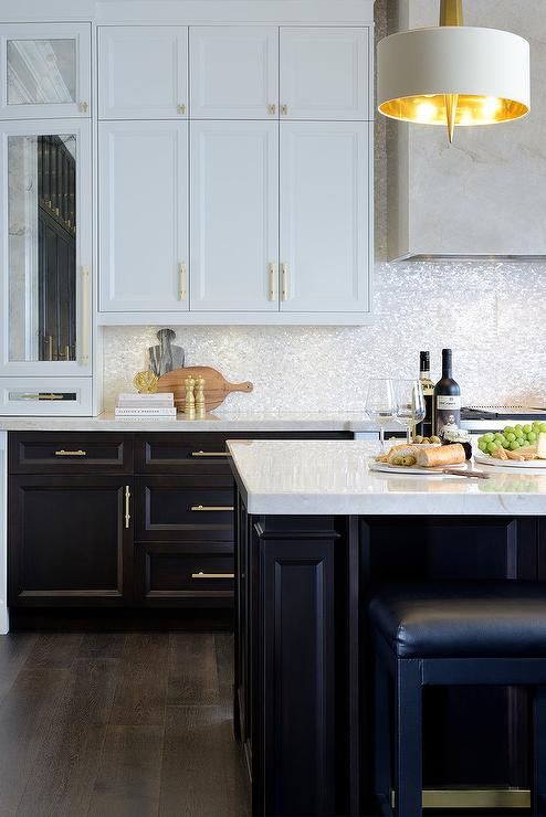 a kitchen with white cabinets and black counter tops, along with an island in the middle