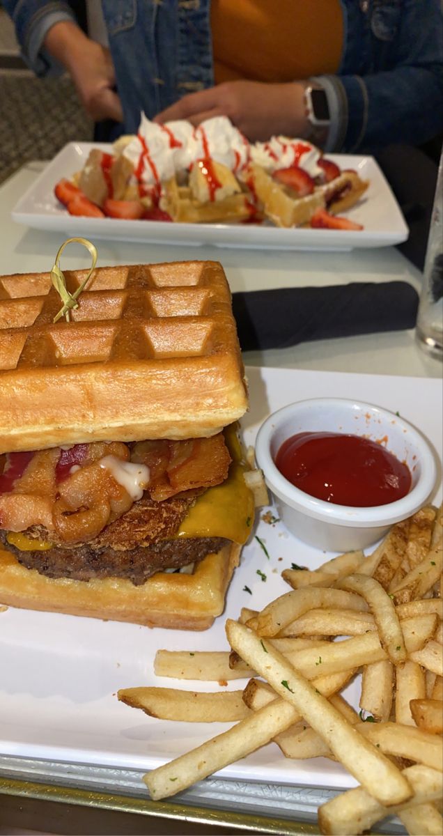 two plates with waffle sandwiches and french fries on them, along with ketchup