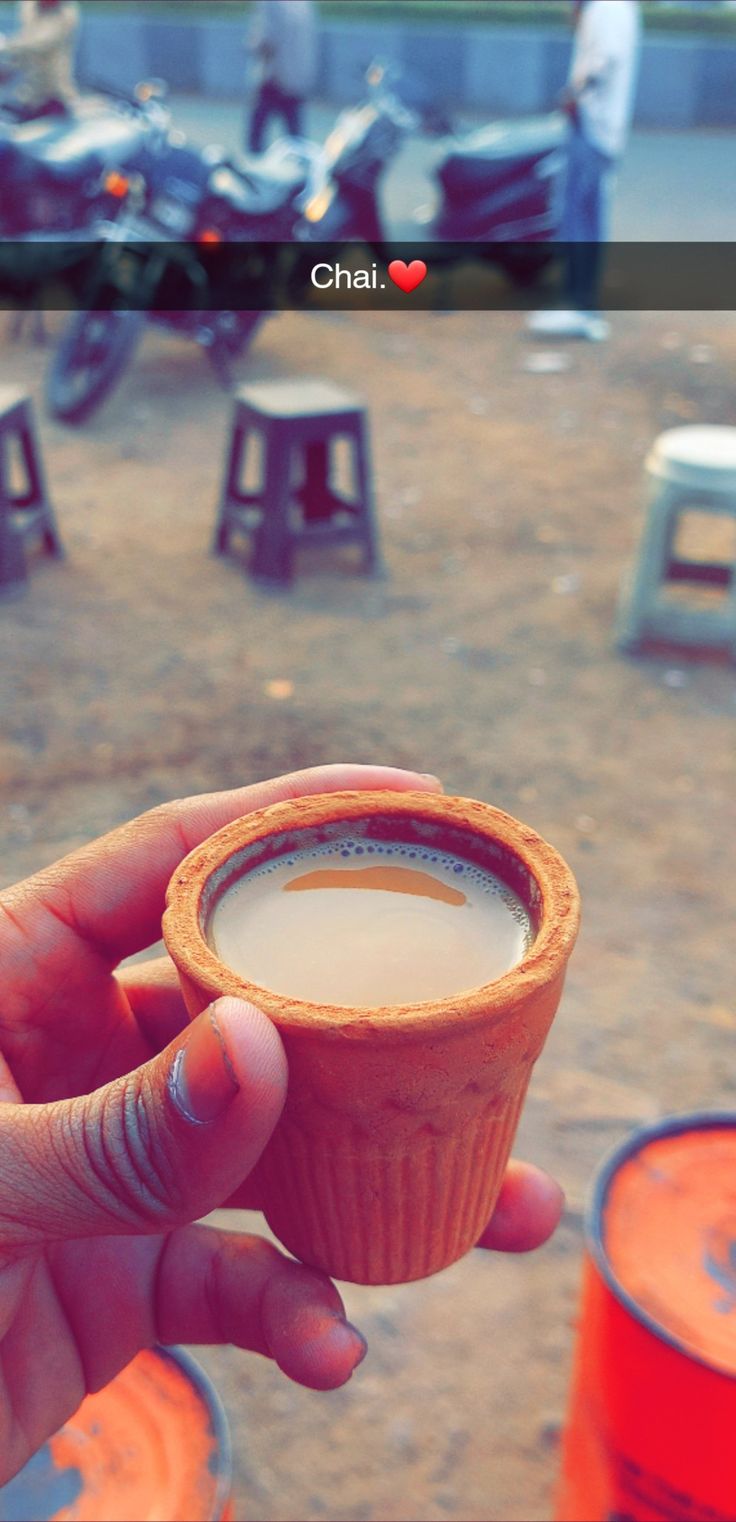 a person holding a cup of coffee in their hand