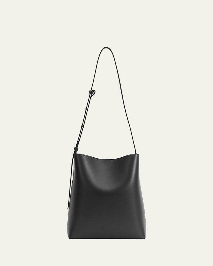 Buy from $605.00: The Aesther Ekme bucket bag is crafted in smooth calfskin leather. The bag features an adjustable shoulder strap, open top with magnetic closure, and a center slip compartment that divides the interior. The bag measures approximately 17.3"H x 7.6"W x 4.5"D. It is made in Spain. Adjustable Bag, Shoulder Strap Bag, Black Bag, Open Top, Magnetic Closure, Smooth Leather, Leather Shoulder Bag, Bucket Bag, Calf Skin