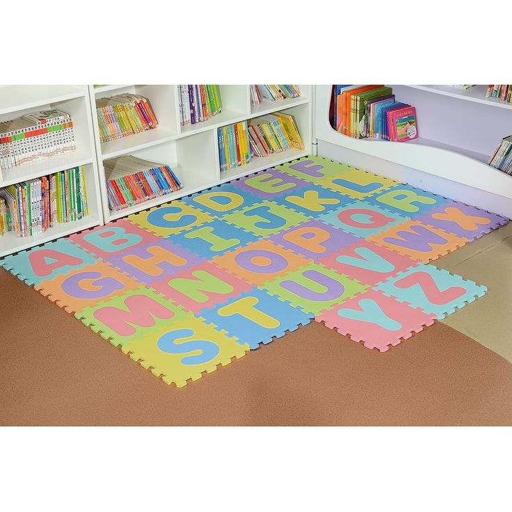 a child's play area with bookshelves and rugs in the shape of numbers