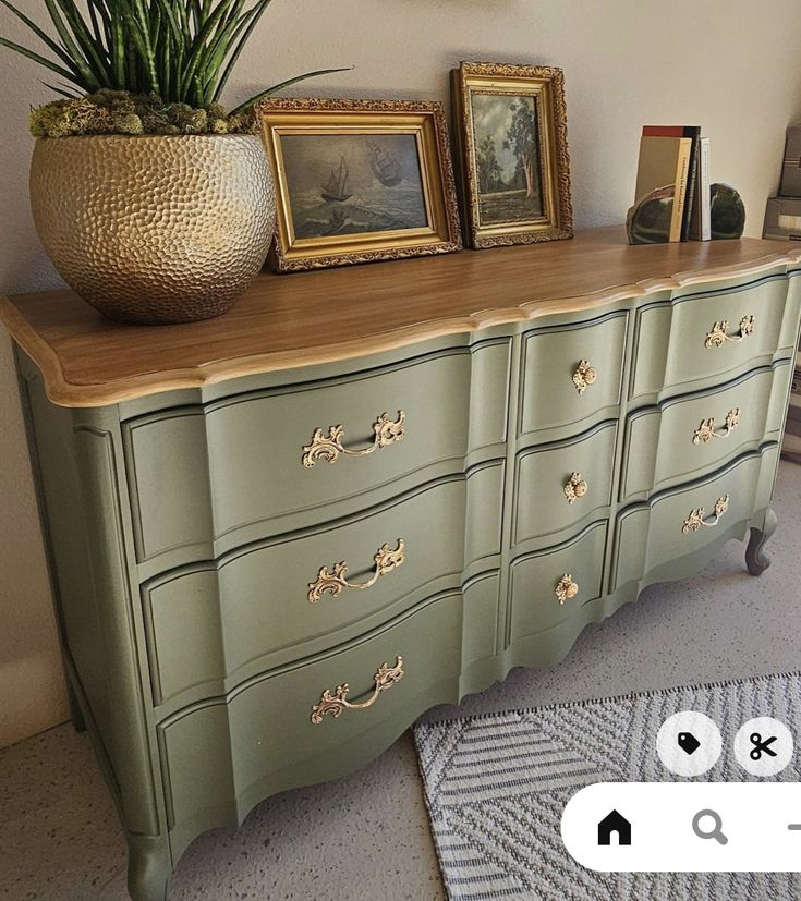 an old dresser has been painted green with gold details