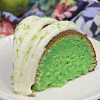 a piece of green cake with white frosting on a plate