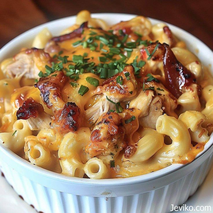 a white bowl filled with macaroni and cheese covered in bacon