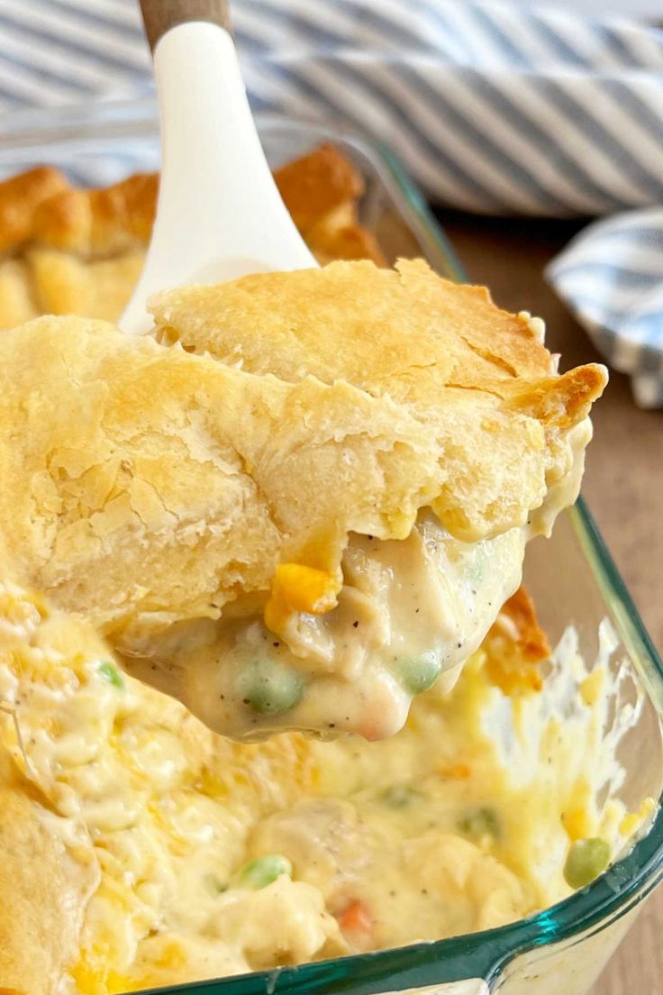 a spoonful of chicken pot pie casserole is being lifted from the casserole dish