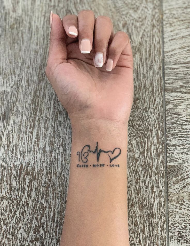 a woman's wrist with a heartbeat tattoo on the left side of her arm