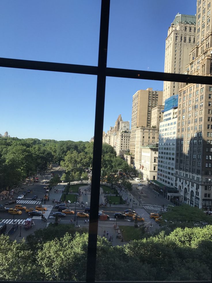 the view from an office building looking down on a parking lot and skyscrapers in new york city