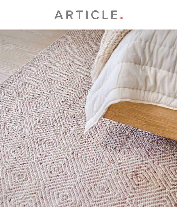 a bed sitting on top of a wooden floor next to a rug