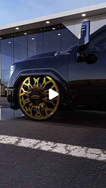 a black car with yellow wheels parked in front of a building