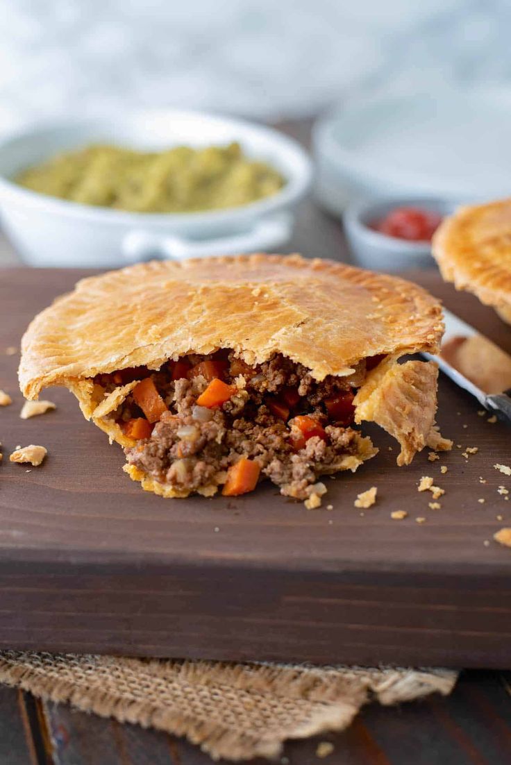 a meat pie is cut in half on a cutting board