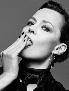 a black and white photo of a woman with her hands in her mouth while wearing a bow tie