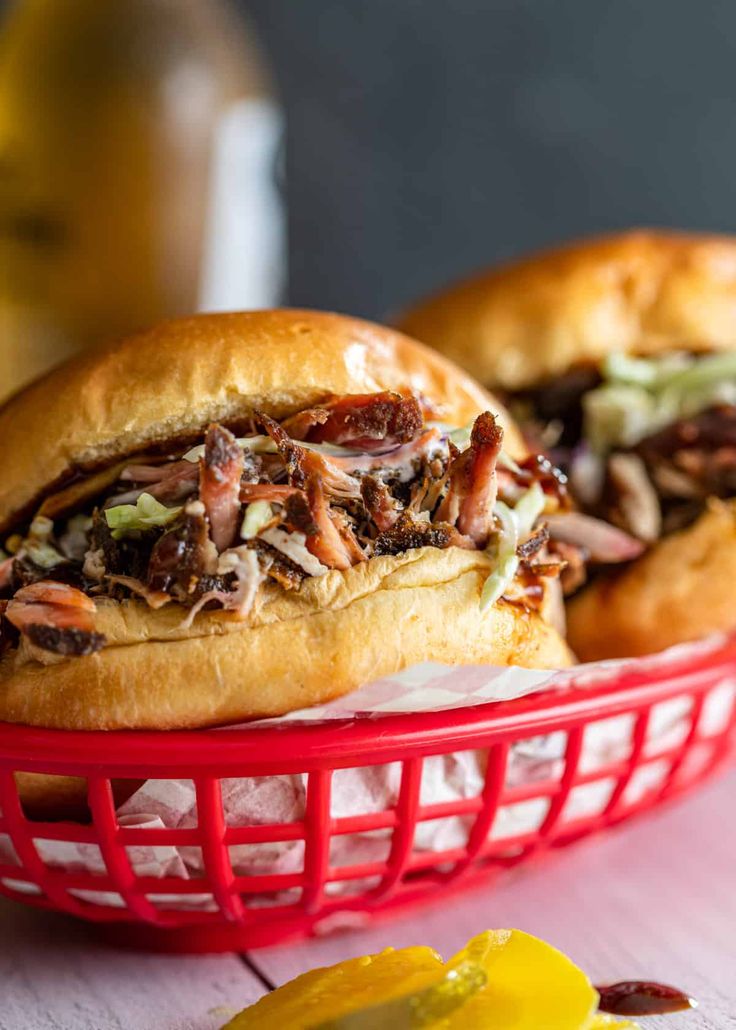 two pulled pork sandwiches in a red basket