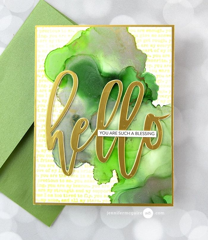 a card with the words hello on it and green watercolor paint splatters