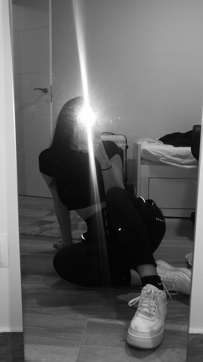 a person sitting on the floor in front of a mirror