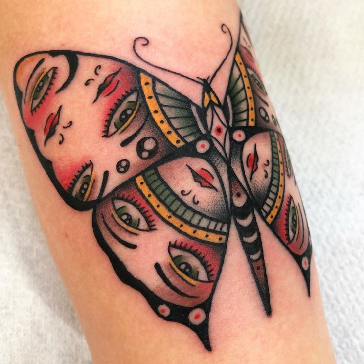 a close up of a butterfly tattoo on the leg