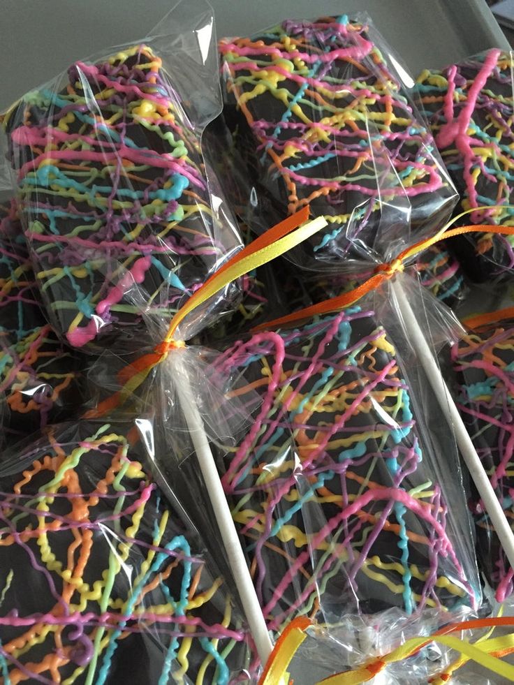 colorful sprinkles are wrapped in plastic on top of cake pops and sticks