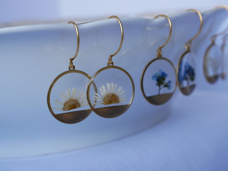 These small round brass frames that are evocative of the sun on the horizon hang from 24k gold plated ear hooks. Available in your choice of real preserved botanical: Queen Anne's Lace is a symbol of sanctuary The Daisy is a symbol of hope Forget-me-nots are known as a symbol of lasting friendship, love, and remembrance Materials are tarnish resistant. However, please see our care section for info on keeping your piece lovely for years to come. All materials are nickel and lead free. Ships in a Everyday Gold Jewelry With Pressed Flowers, Gold Sterling Silver Birth Flower Earrings, Nature-inspired Round Hoop Earrings For Gift, Nature-inspired Hoop Earrings As Gift, Nature-inspired Nickel-free Round Flower Earrings, Nature-inspired Round Pressed Flowers Earrings, Nature-inspired Round Brass Earrings, Sterling Silver Round Birth Flower Earrings, Brass Flower Earrings Gift