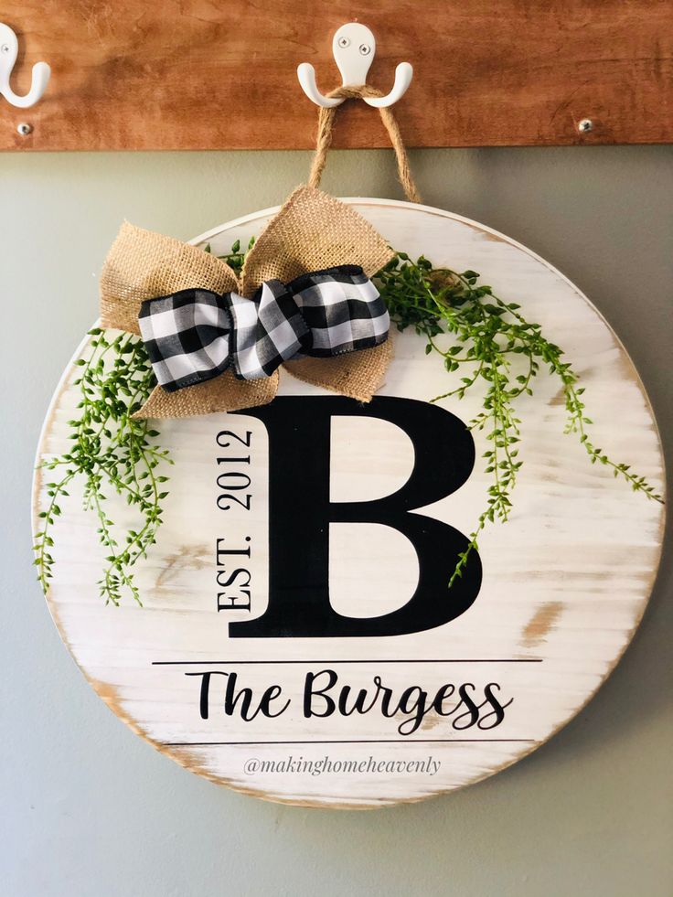 a wooden sign hanging on the wall with a bow around it's letter b