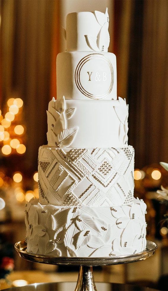 a three tiered white wedding cake sitting on top of a table