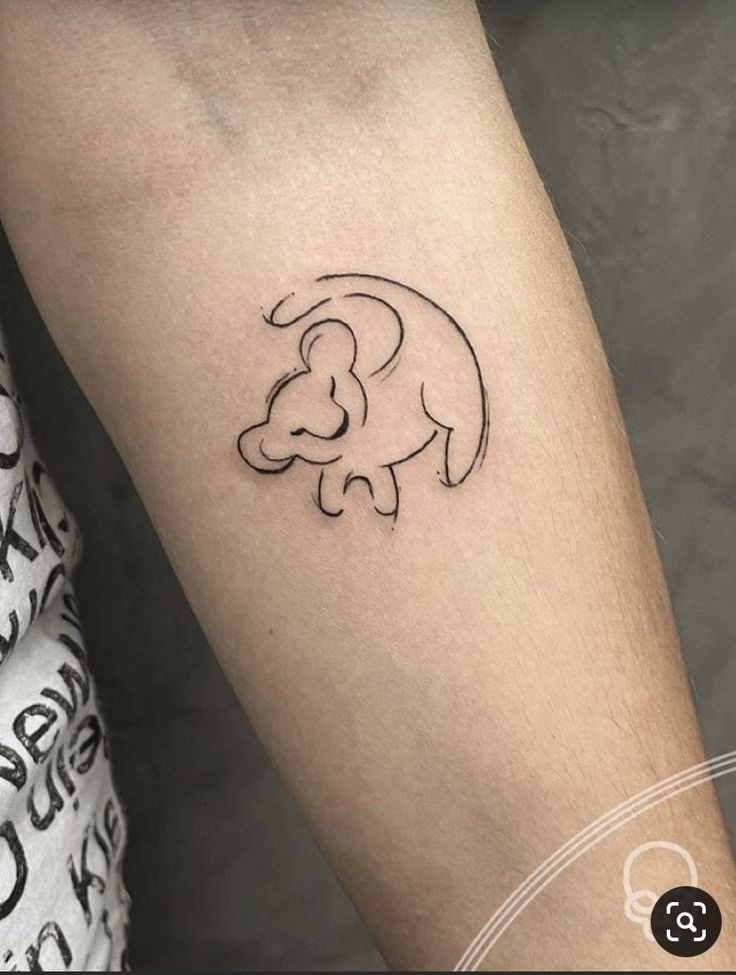 a small elephant tattoo on the left forearm and arm, with an outline of a baby elephant