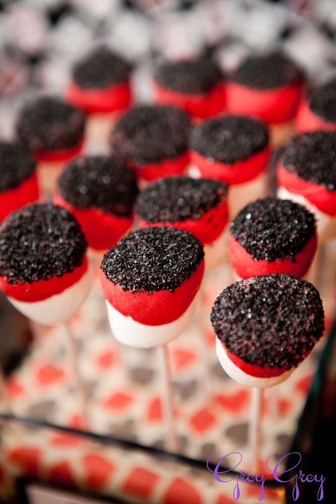 red and black cupcakes on sticks with white frosting