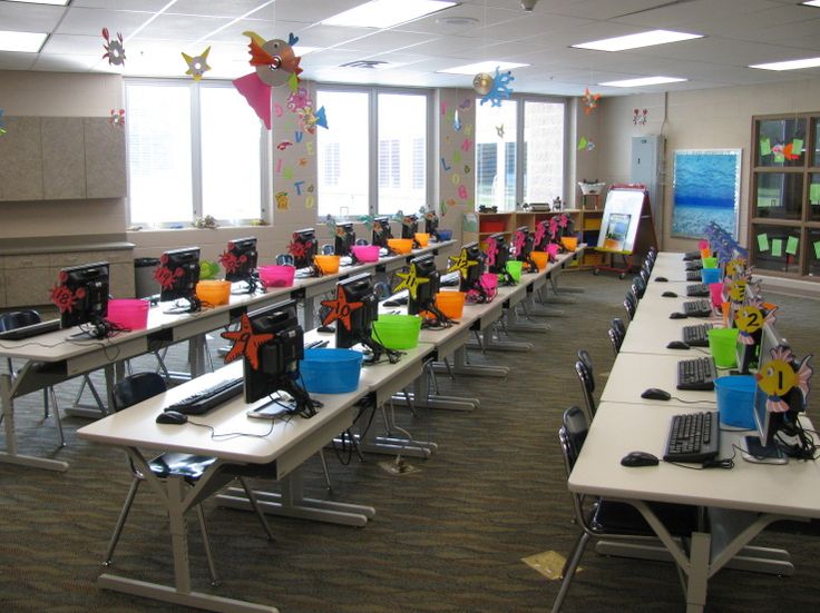 an empty classroom with desks and laptops covered in decorations on the desks