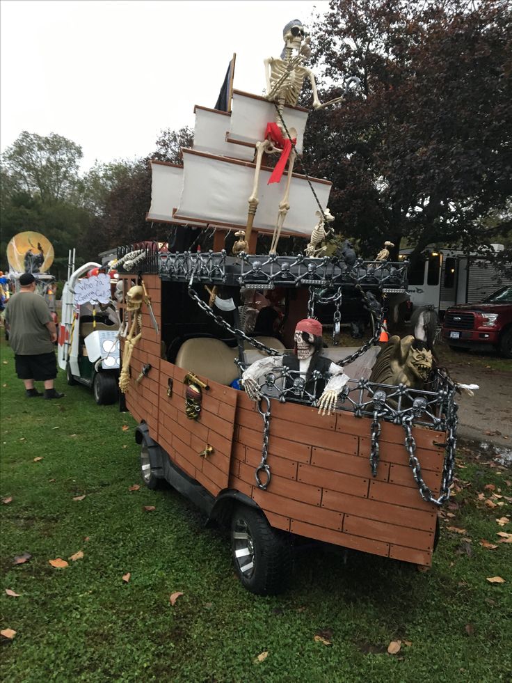 a group of people riding on the back of a truck decorated like a pirate ship