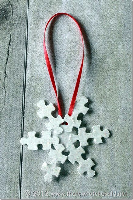 a snowflake ornament hanging from a red ribbon